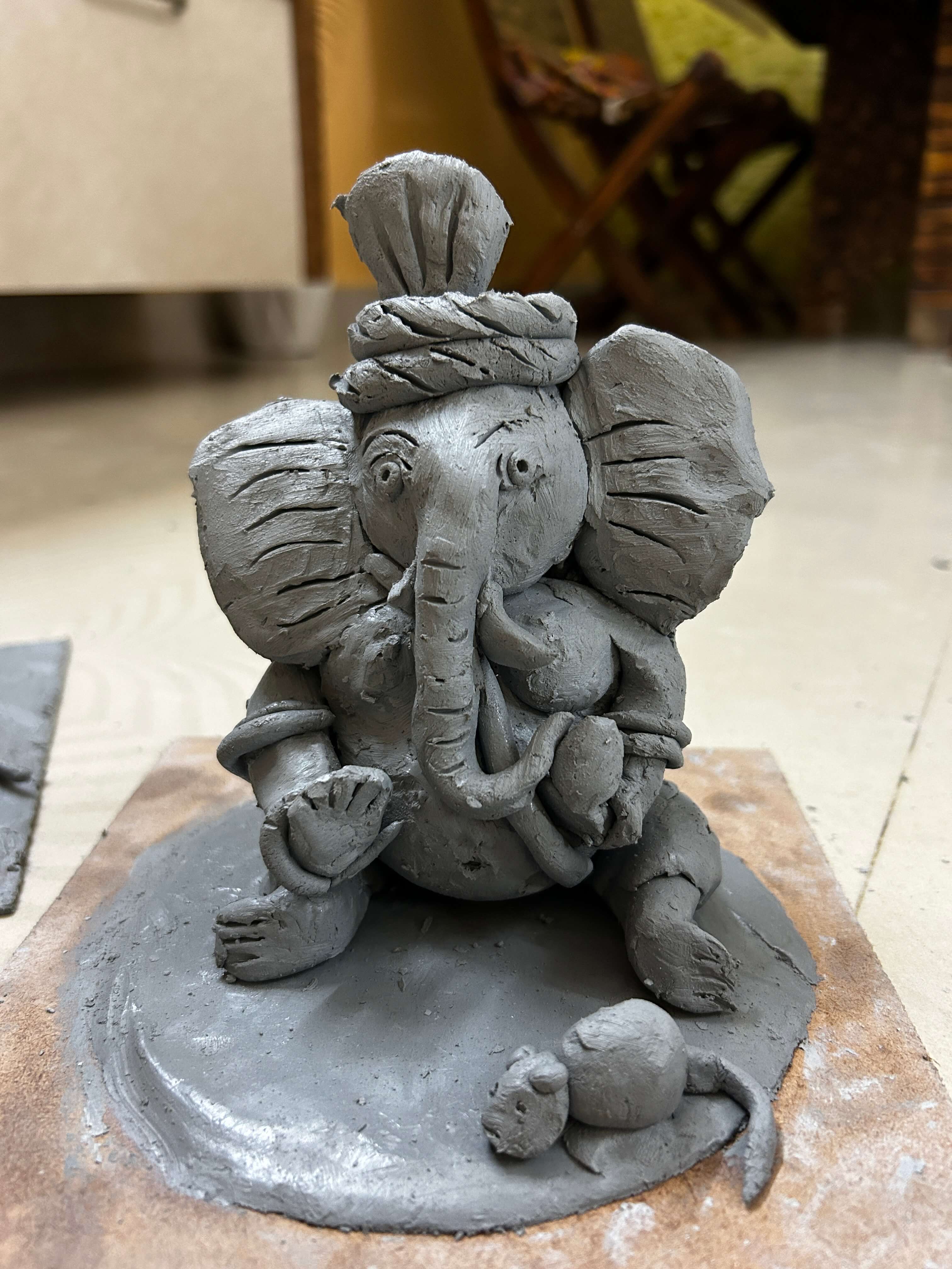 A participant adding final touches to their handmade Ganesh idol